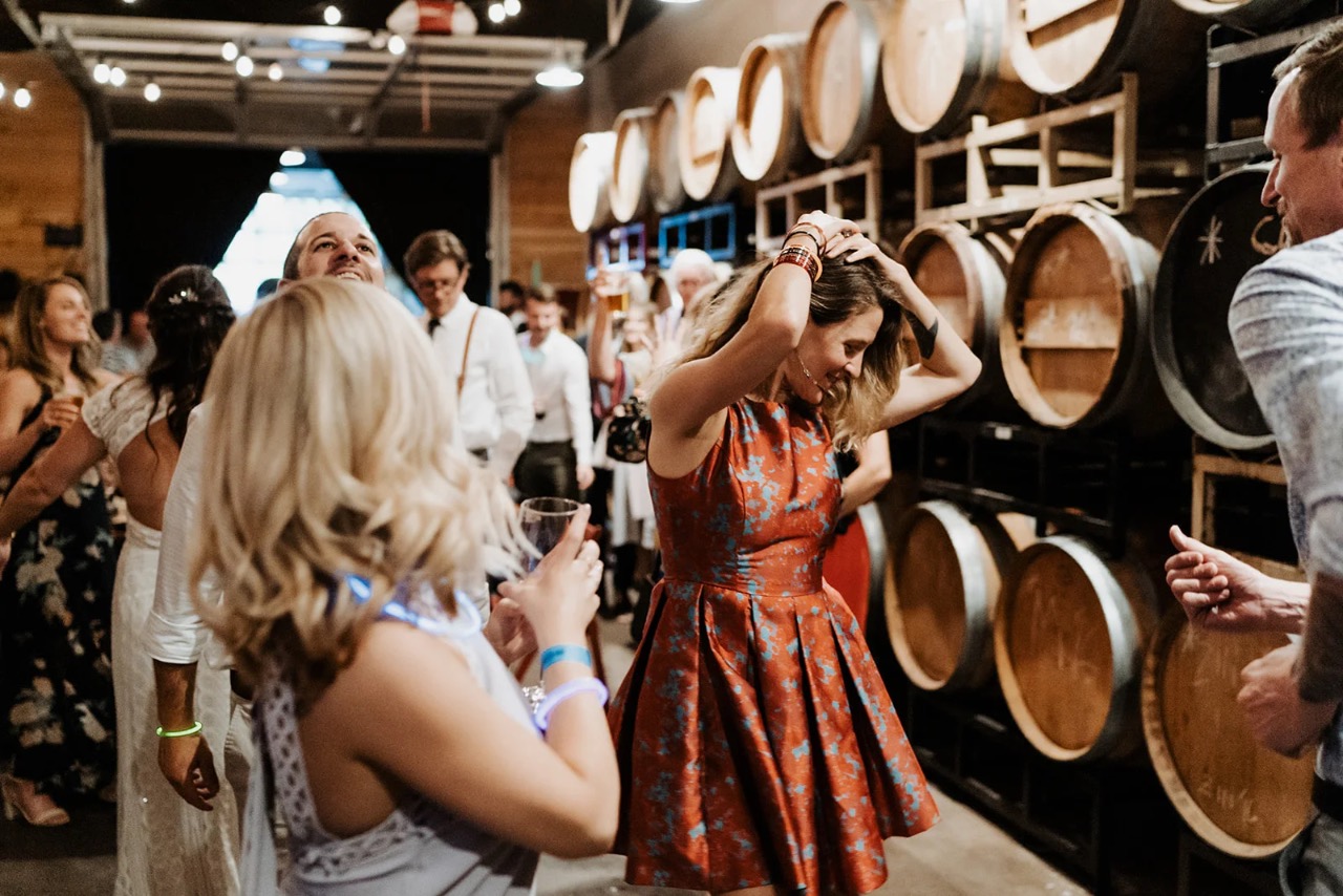 Guests celebrating among the wine barrels at ENSO