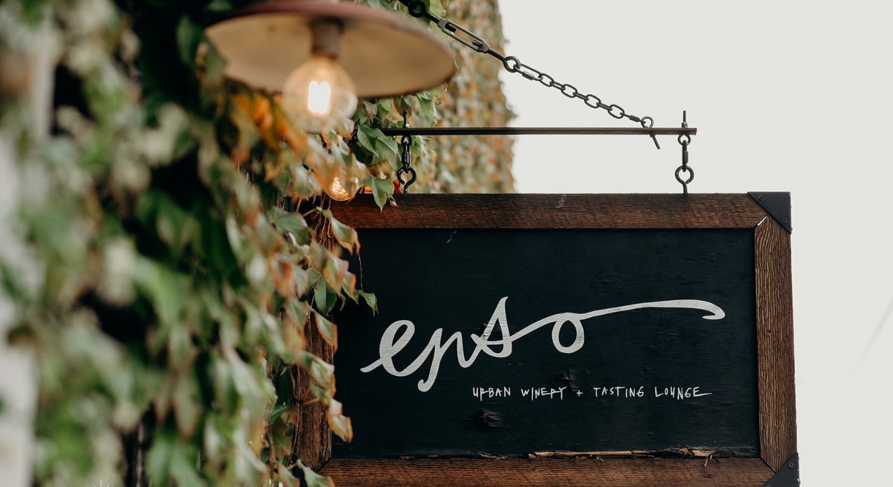 The hand-lettered ENSO sign amid climbing ivy